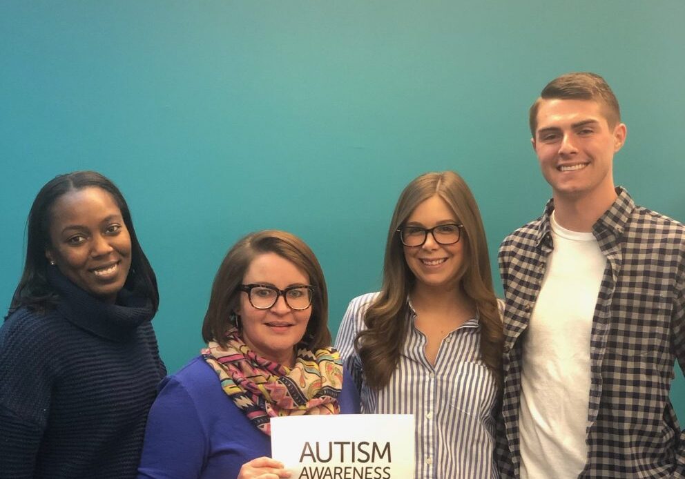 Chimes Holcomb staff hold Autism Awareness Month sign